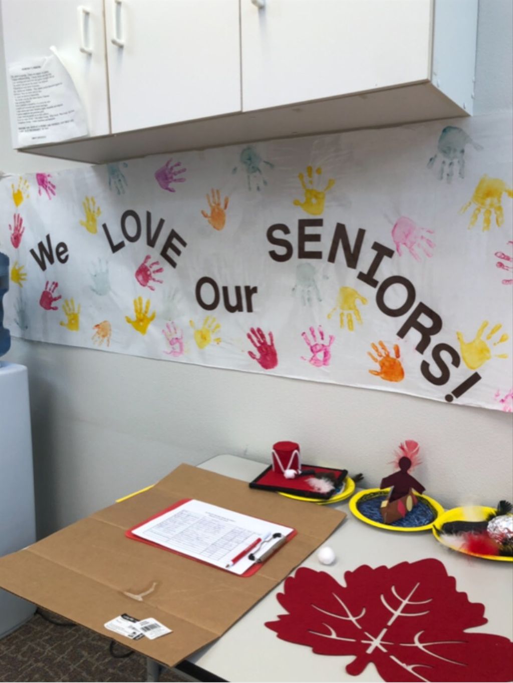 Decorated office space with painted handprints and text that reads "We love our seniors!"