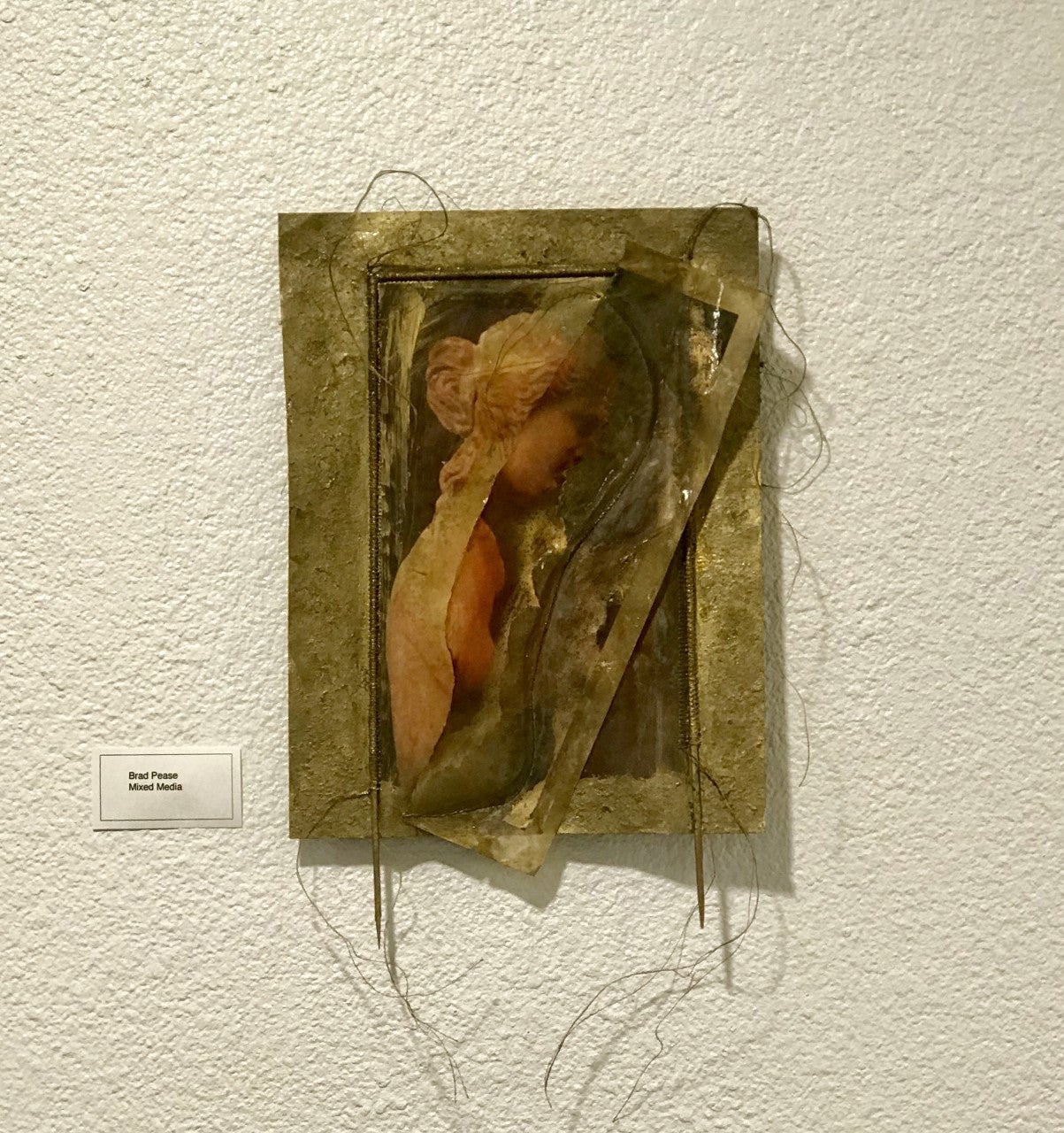 An art piece of a woman's profile on metal.