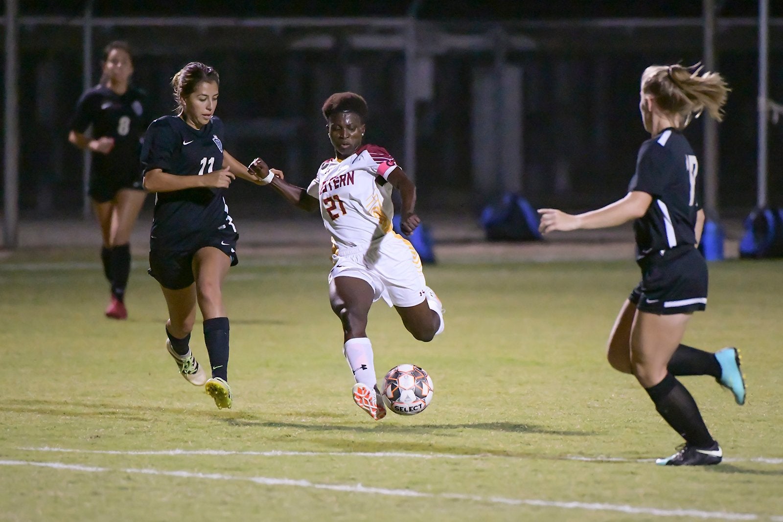 African American soccer player runs to kick a ball on the field