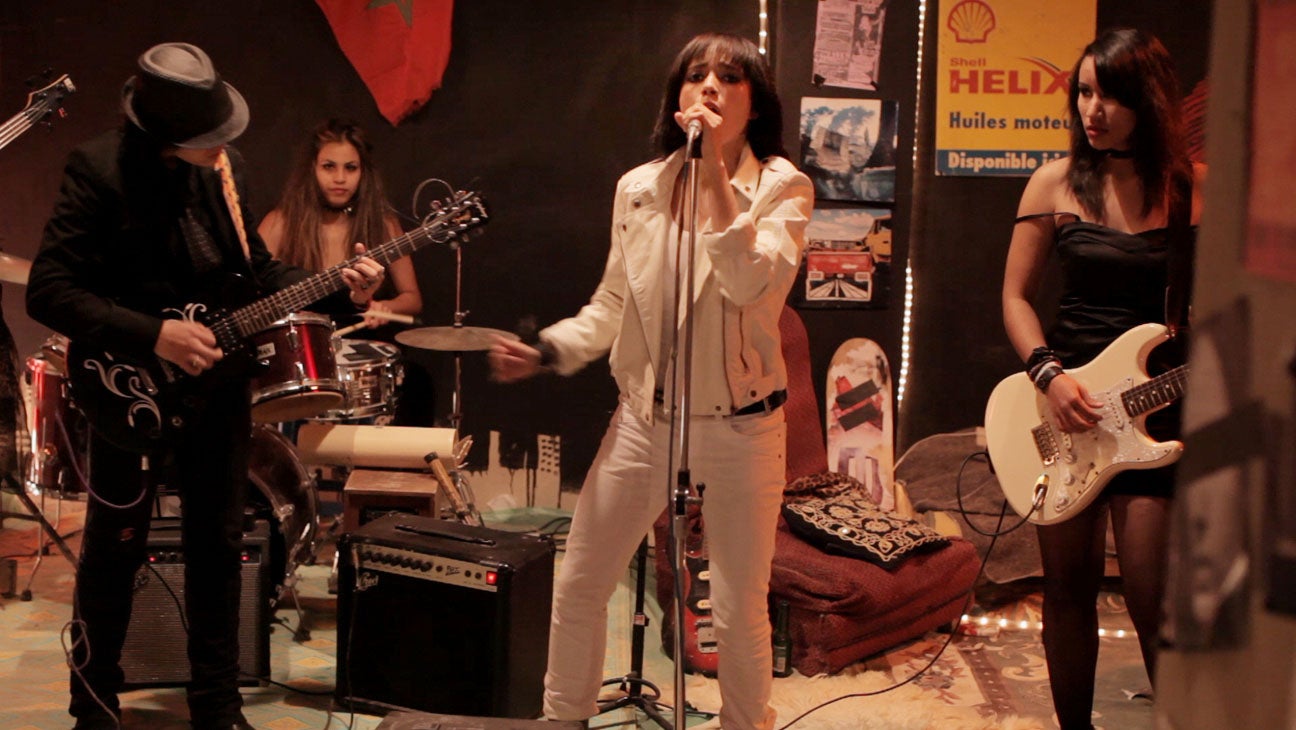 Girl signing in front of her band.