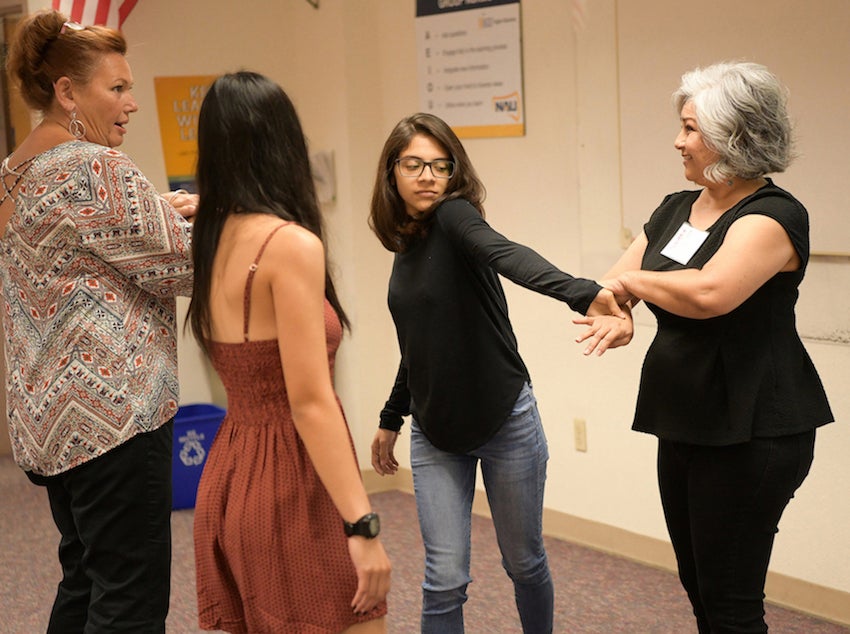 Instructor teaching group of women a self-defense tactic.