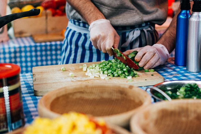 Person cutting spring onion to prepare food