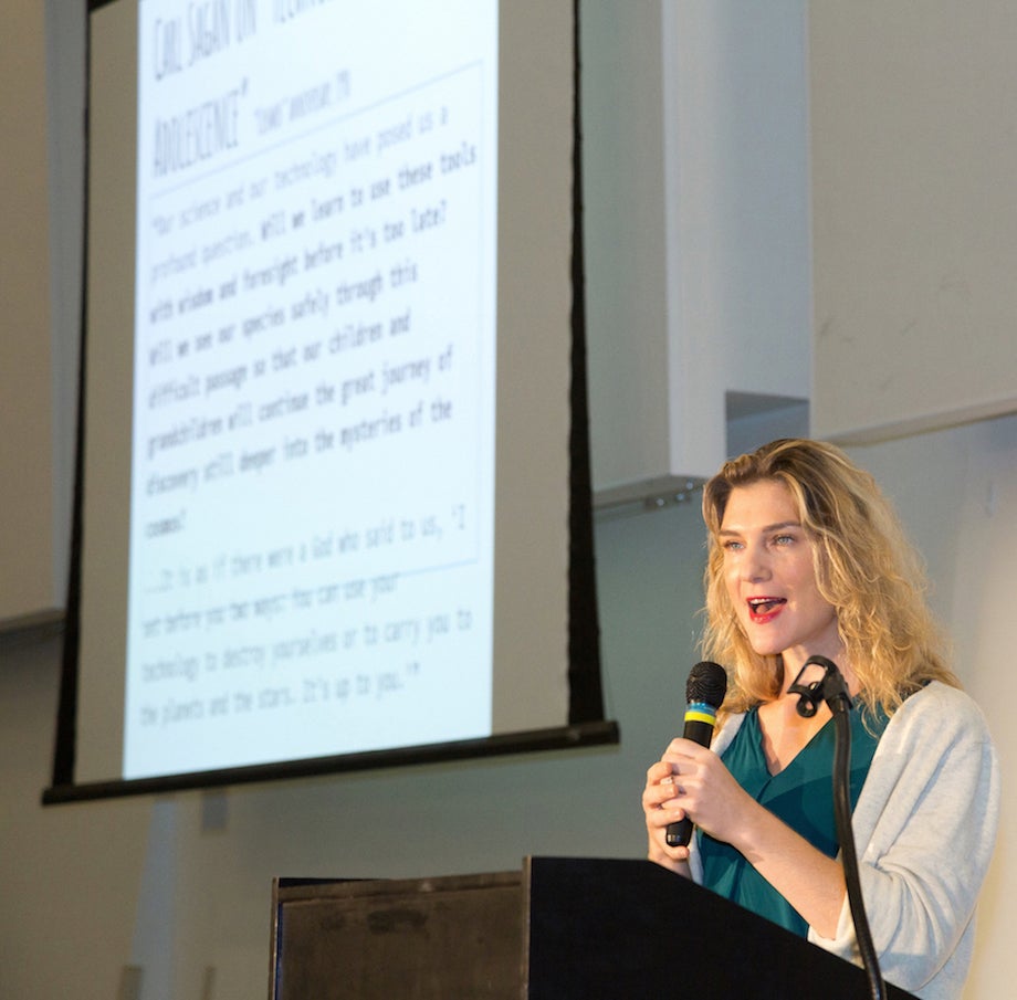 Female speaker in front of a projected screen