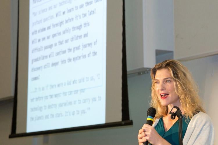 Female speaker in front of a projected screen